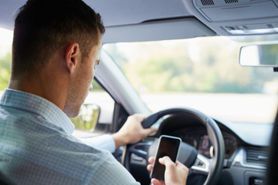 携帯を使用しながら運転する人