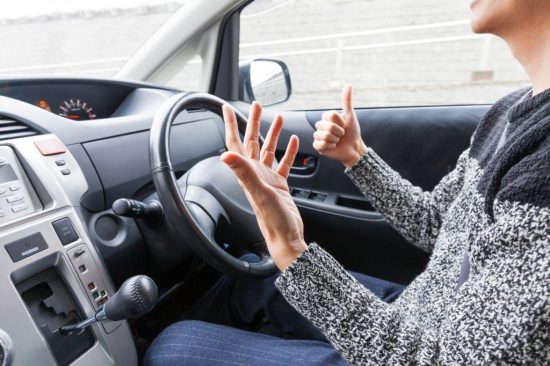 手放しで車を運転する男性