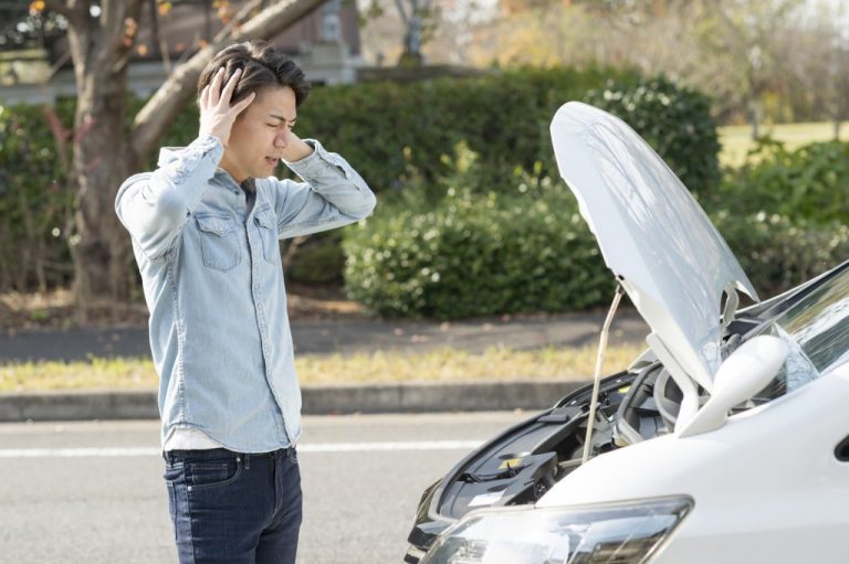 車のトラブルで困っている男性