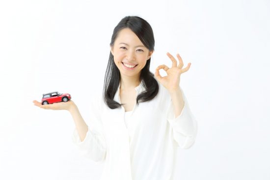 車を手に乗せてOKサインを出す女性