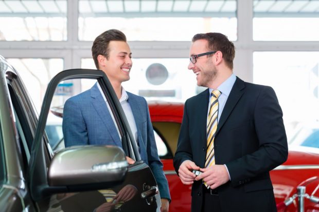 車の営業マンと交渉する男性