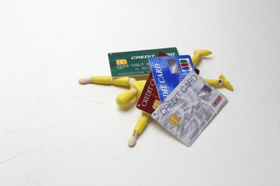 クレジットカードに押しつぶされる人形