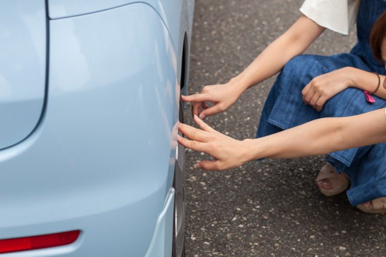 車の傷を確かめる女性