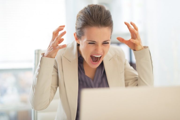 パソコンの前で叫ぶ女性